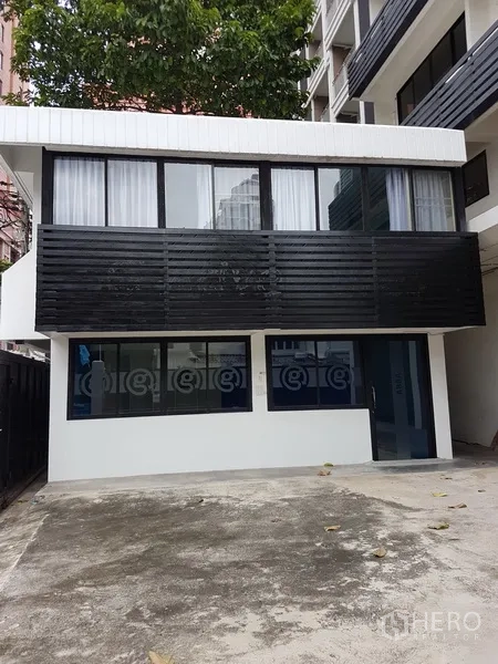 Home Office for sale in Khlong Toei, Bangkok - Detached annex building with wide windows facing a concrete yard.