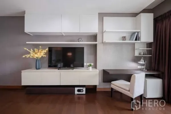 Condominium for rent or sale in Watthana, Bangkok - Thonglor condo living area with built-in TV wall, floating shelves, work desk and hardwood floors.