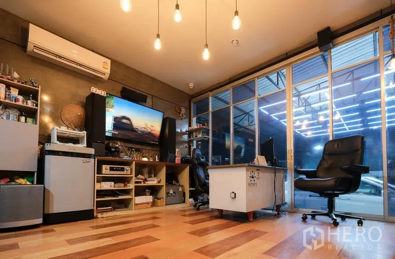 Warehouse for rent in Bueng Kum, Bangkok - Air-conditioned office inside the warehouse with wood flooring, pendant lights, and a sliding glass wall.