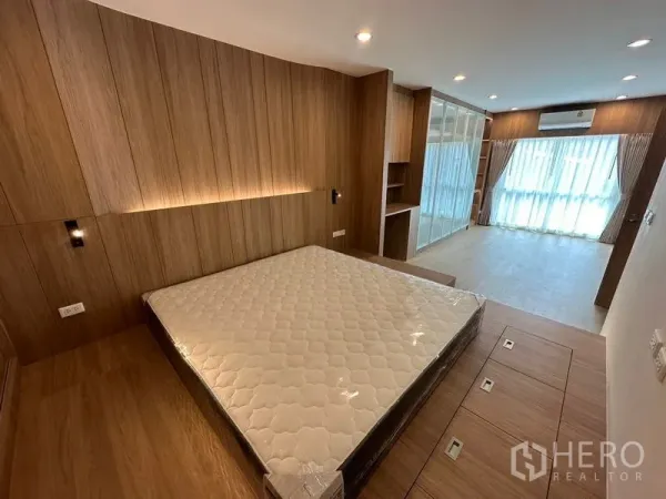 带办公室的家 出租在Khlong Toei, Bangkok - 主卧带木质背景墙、平台床与落地窗帘。