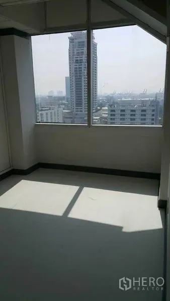 Office Space for rent in Khlong Toei, Bangkok - Bright corner room with large window and high-rise city views.