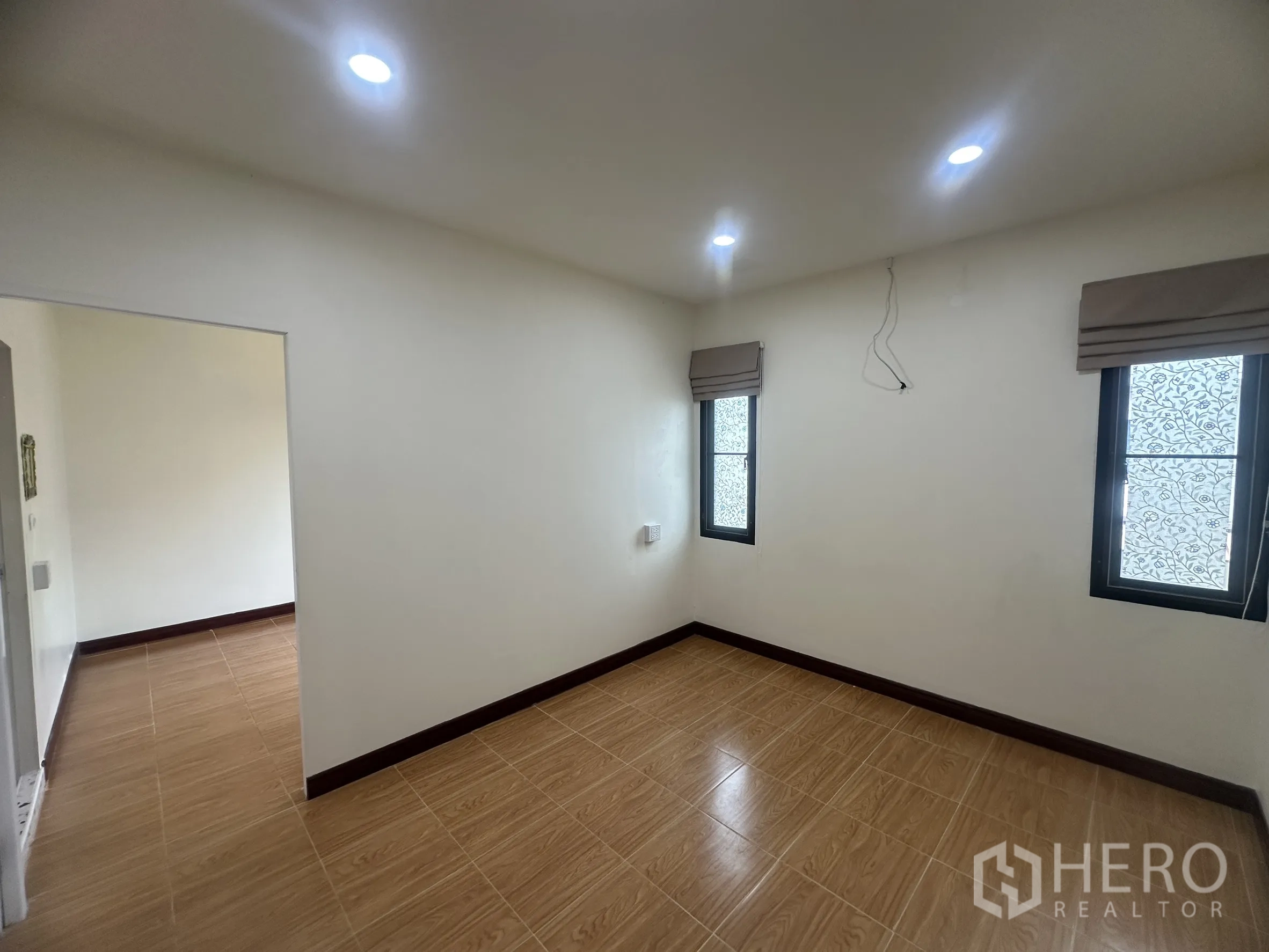Townhouse for sale in Lam Luk Ka, Pathum Thani - Upstairs bedroom with two windows and tiled floors.