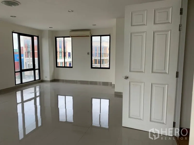 Office Space for rent in Bang Kho Laem, Bangkok - Bright corner office with several windows and a white paneled door.