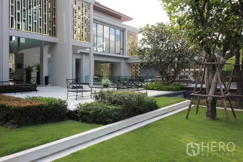 Detached House for rent or sale in Prawet, Bangkok - Modern community clubhouse exterior with landscaped gardens and terrace seating.