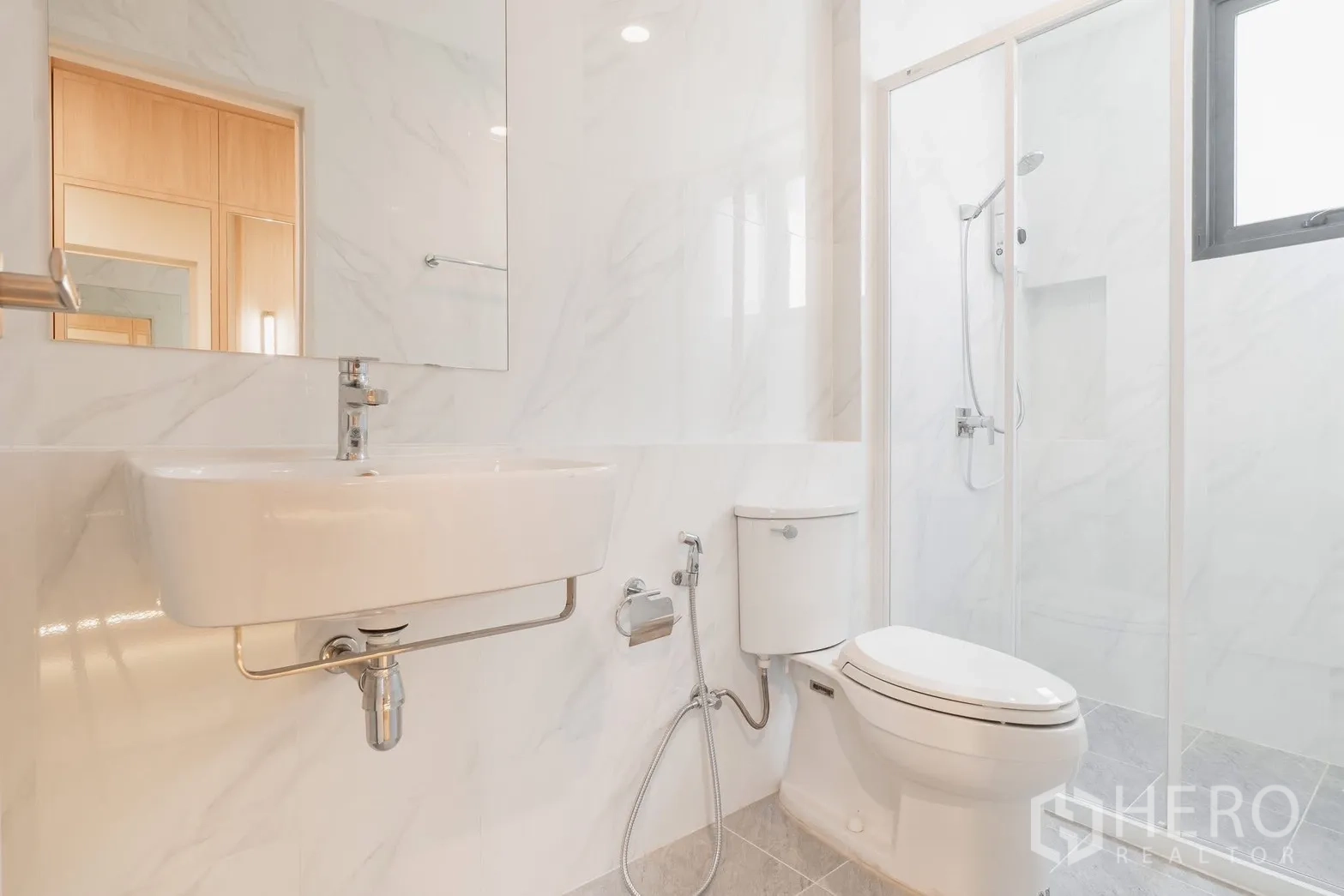 Detached House for rent or sale in Prawet, Bangkok - Bright guest bathroom with white tiles, shower and toilet