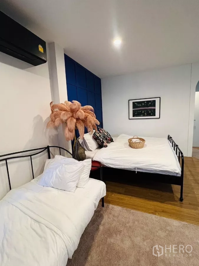 Detached House for rent in Saphan Sung, Bangkok - Guest bedroom with two beds and a navy paneled headboard.