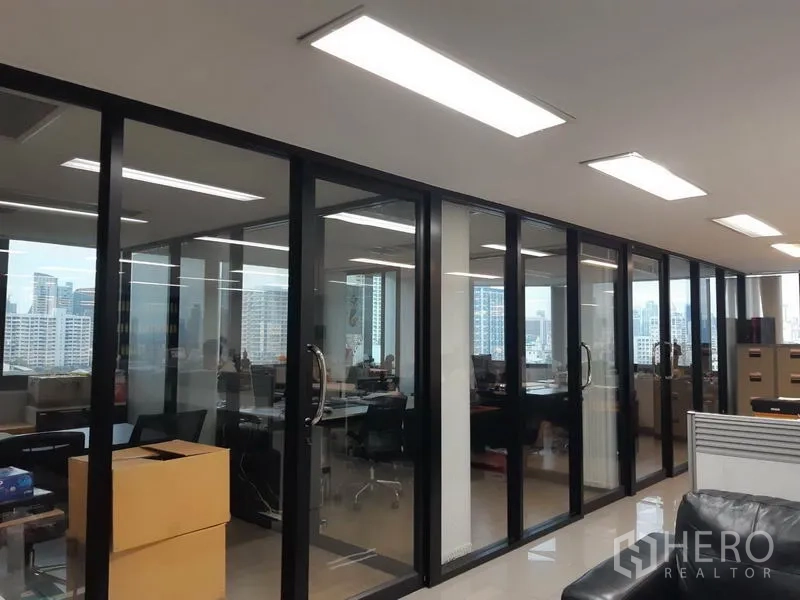 Office Space for sale in Khlong Toei, Bangkok - Row of glass-partitioned private offices with LED lighting and skyline views.