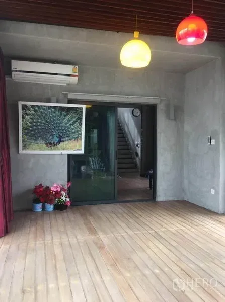 独立式住宅 出售在Pak Kret, Nonthaburi - 有顶露台，木地板与彩色吊灯，配推拉玻璃门。