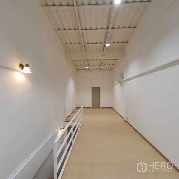 Shophouse for rent or sale in Khlong Toei, Bangkok - Long mezzanine level with high ceiling, white walls and safety railing.