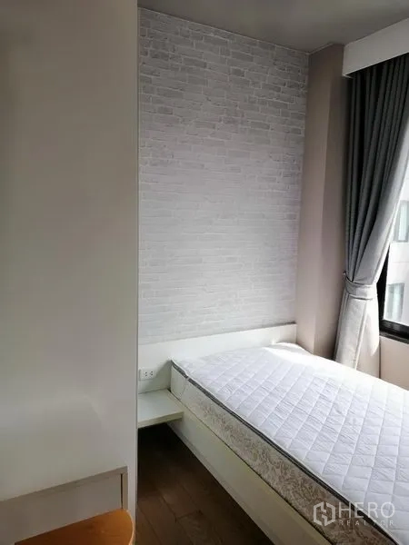Condominium for rent in Watthana, Bangkok - Second bedroom with single bed, brick-style feature wall and large window