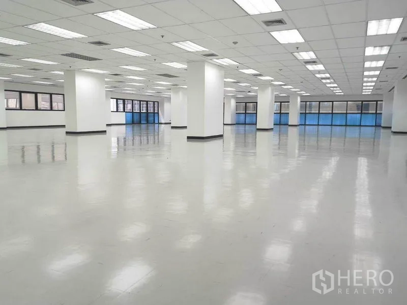 Office Space for rent in Phaya Thai, Bangkok - Open office area showing multiple pillars, suspended ceiling panels and natural light from broad windows.