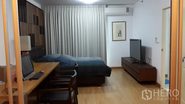 公寓 出租在Huai Khwang, Bangkok - 木地板卧室起居区，配置床、长工作台、电视柜、窗帘与空调