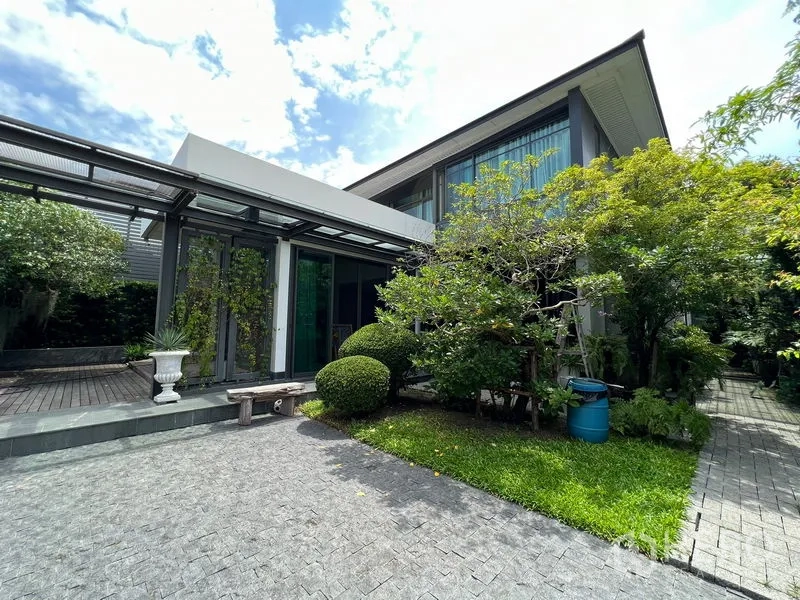Detached House for sale in Bang Kapi, Bangkok - Front view of a modern two-storey detached house with large windows and landscaped garden.
