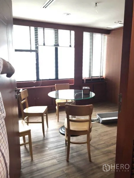 Office Space for sale in Watthana, Bangkok - Small meeting room with a round glass table and chairs by large windows.