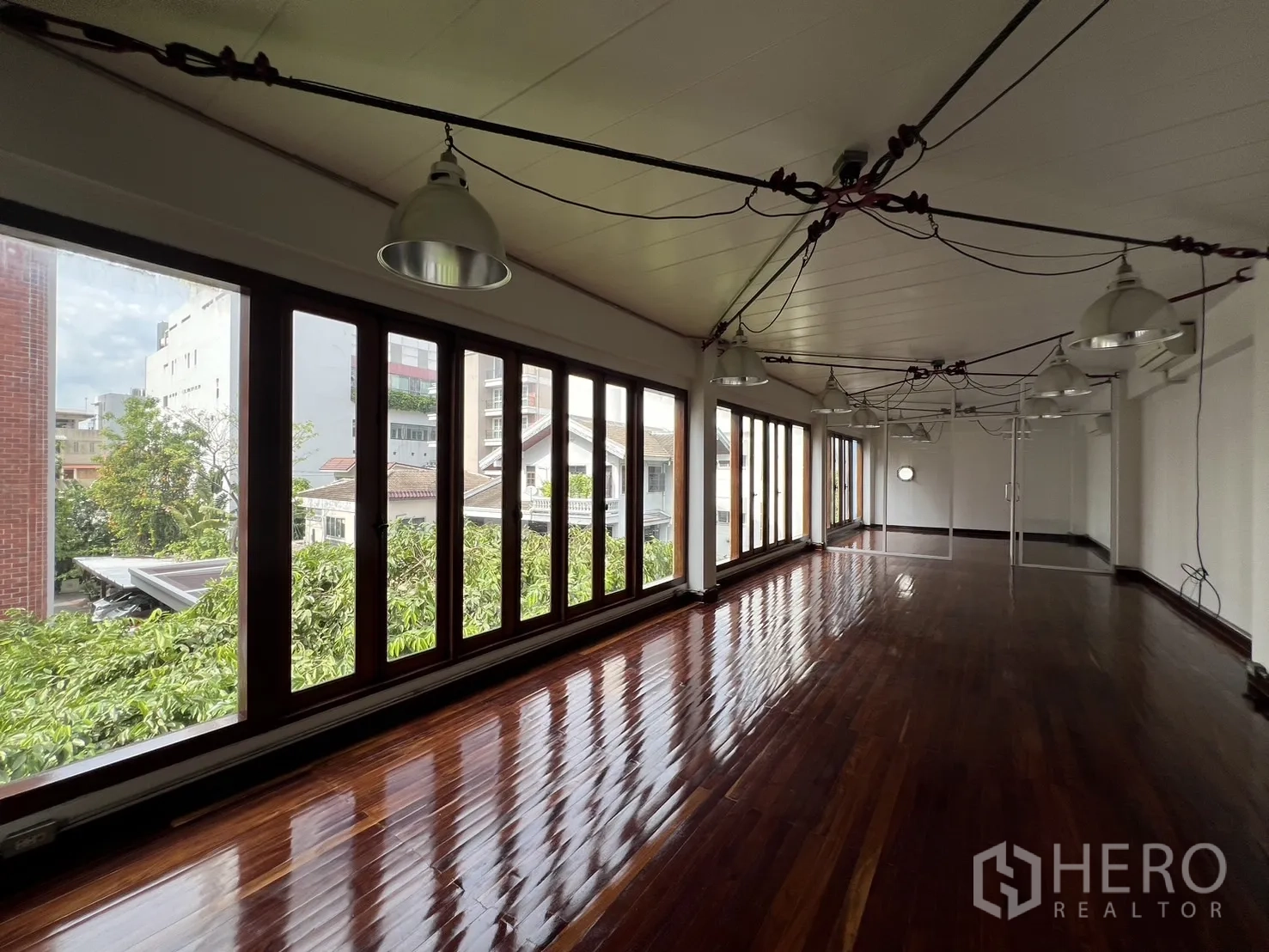 带办公室的家 出租在Watthana, Bangkok - 开放式办公层，抛光木地板、整排落地窗与工业风吊灯。