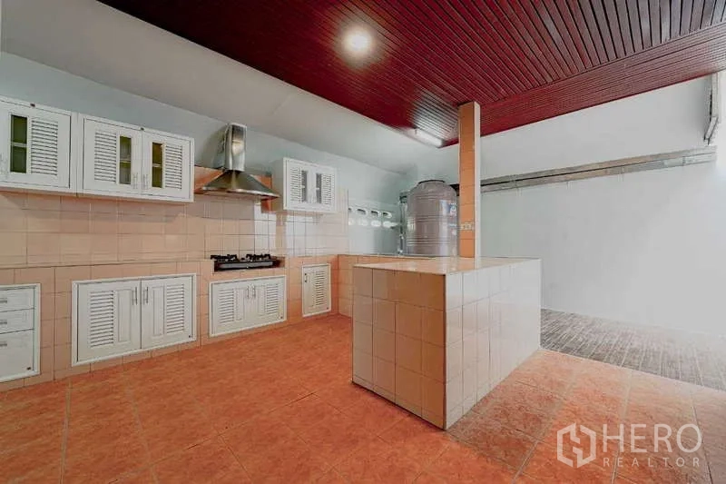 Detached House for rent or sale in Phra Khanong, Bangkok - Thai-style secondary kitchen with tiled counters, gas hob, and extractor hood.