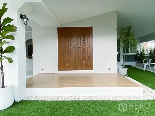 Detached House for rent in Lam Luk Ka, Pathum Thani - Covered porch with tiled platform and ornate wooden double doors.