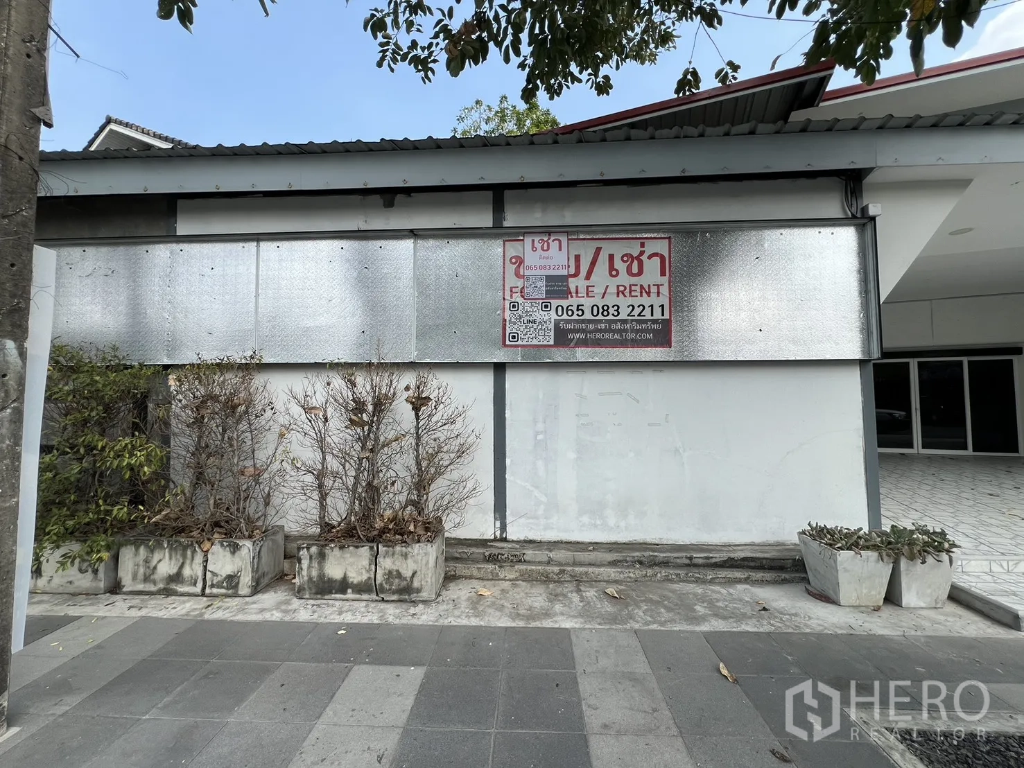 零售空间 for rent in Bueng Kum, Bangkok - 外墙挂有出租招牌，行人道旁设花槽。