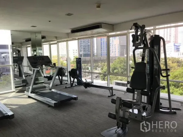 公寓 出租或出售 - 配备有氧与力量器械的健身房，落地窗俯瞰城市。