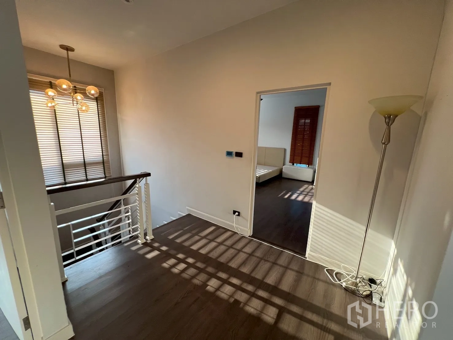 Detached House for rent in Bang Kapi, Bangkok - Hallway by staircase with modern pendant light leading to a bedroom.