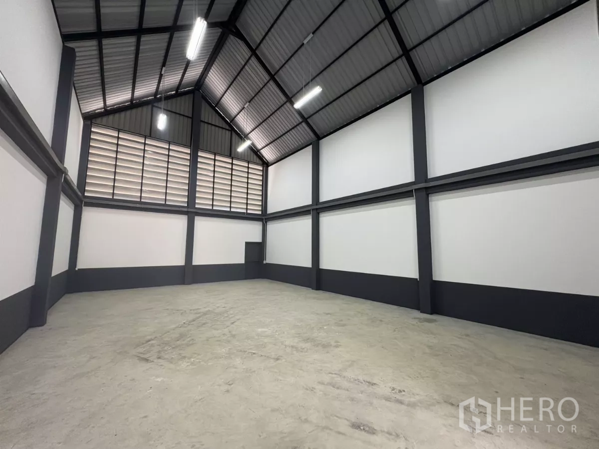Factory for rent or sale in Bang Bua Thong, Nonthaburi - Spacious warehouse hall with high gable ceiling, louvered ventilation and bright lighting.
