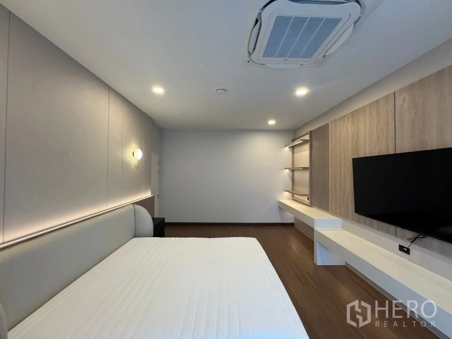 Detached House for rent in Bang Phli, Samut Prakan - Bedroom with ceiling cassette air conditioner, TV wall, and shelving.
