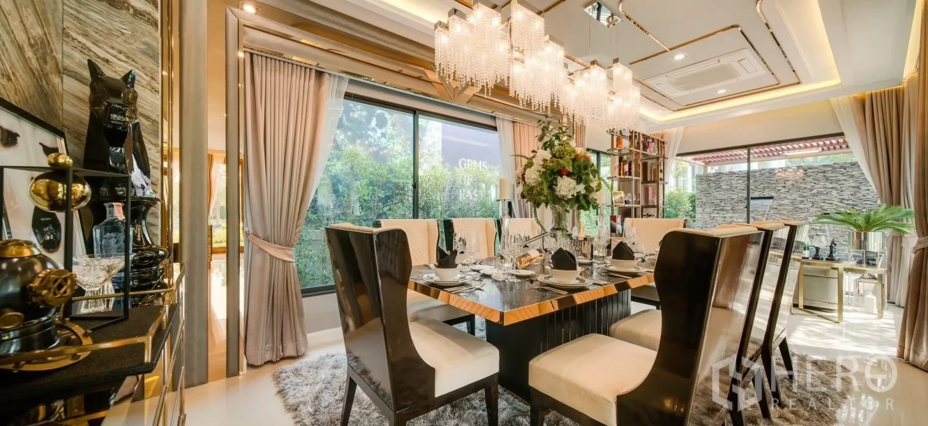 Detached House for rent in Prawet, Bangkok - Elegant dining area with floor-to-ceiling windows, statement chandeliers and eight chairs