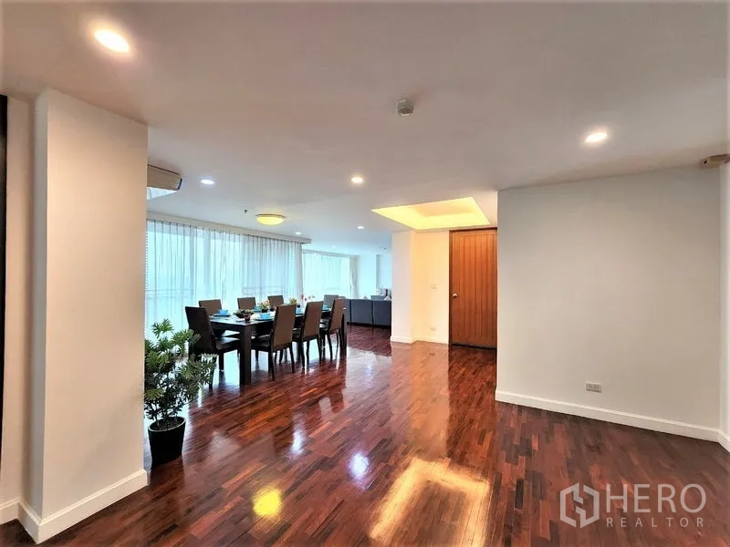 Condominium for rent in Bang Rak, Bangkok - Entry hall leading to the dining area with full-length windows, recessed lights and shiny wooden floors.