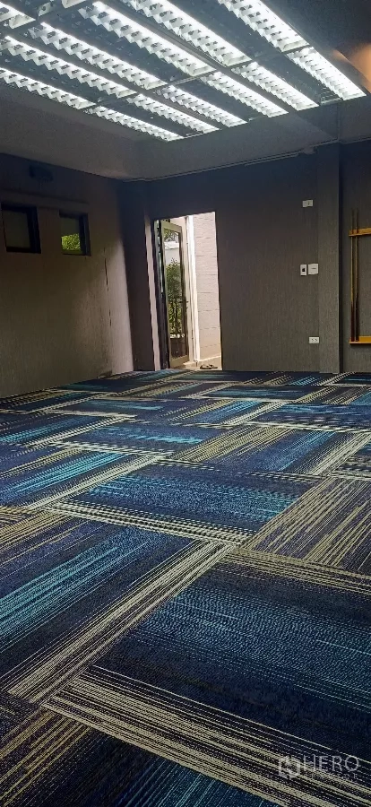 Detached House for rent or sale in Khan Na Yao, Bangkok - Large multipurpose room with patterned blue carpet and strip lighting, door to patio.