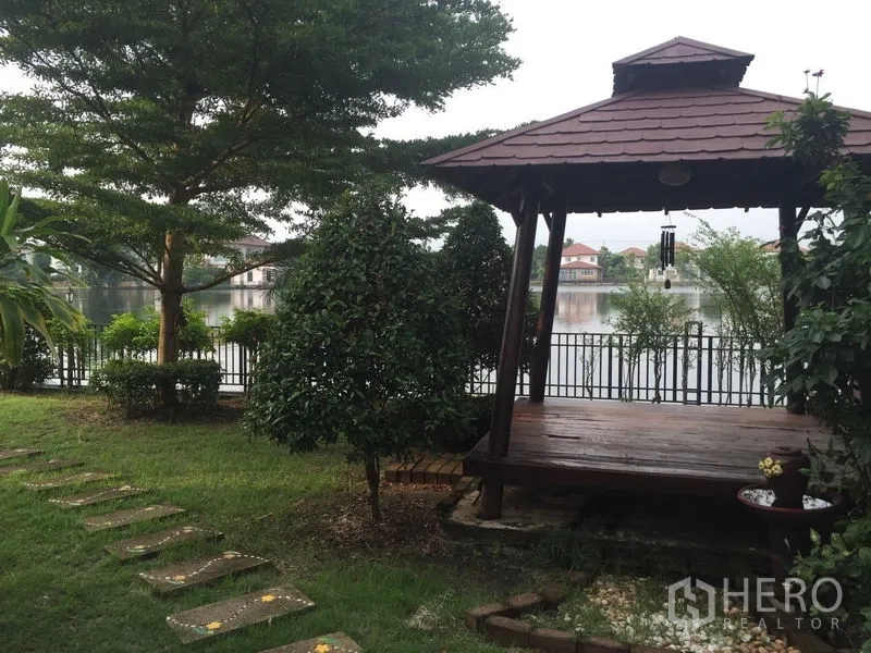 Detached House for rent or sale in Lat Krabang, Bangkok - Lakeside wooden pavilion with landscaped path and water views.