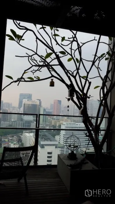 Condominium for rent or sale in Sathon, Bangkok - Balcony with potted tree and expansive skyline view over Sathon.