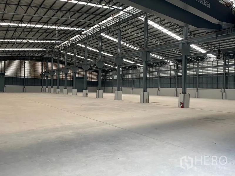 Warehouse for rent in Bang Phli, Samut Prakan - Expansive open warehouse floor with steel columns, clear span structure, skylight panels and smooth concrete surface.