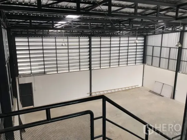 Factory for rent or sale in Lam Luk Ka, Pathum Thani - High-bay warehouse interior with steel trusses, louvered windows, and bright lighting.