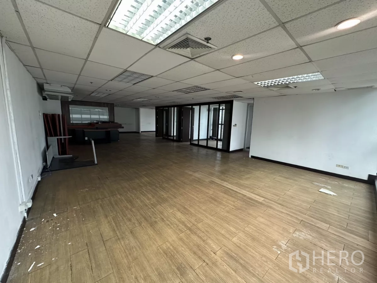 办公空间 出租在Watthana, Bangkok - 宽敞楼层，中央空调出风口与多种灯具，后方为多间玻璃隔断房。
