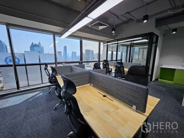 Office Space for rent in Ratchathewi, Bangkok - Open-plan office with wooden desks, partition screens and panoramic city skyline through floor‑to‑ceiling windows.
