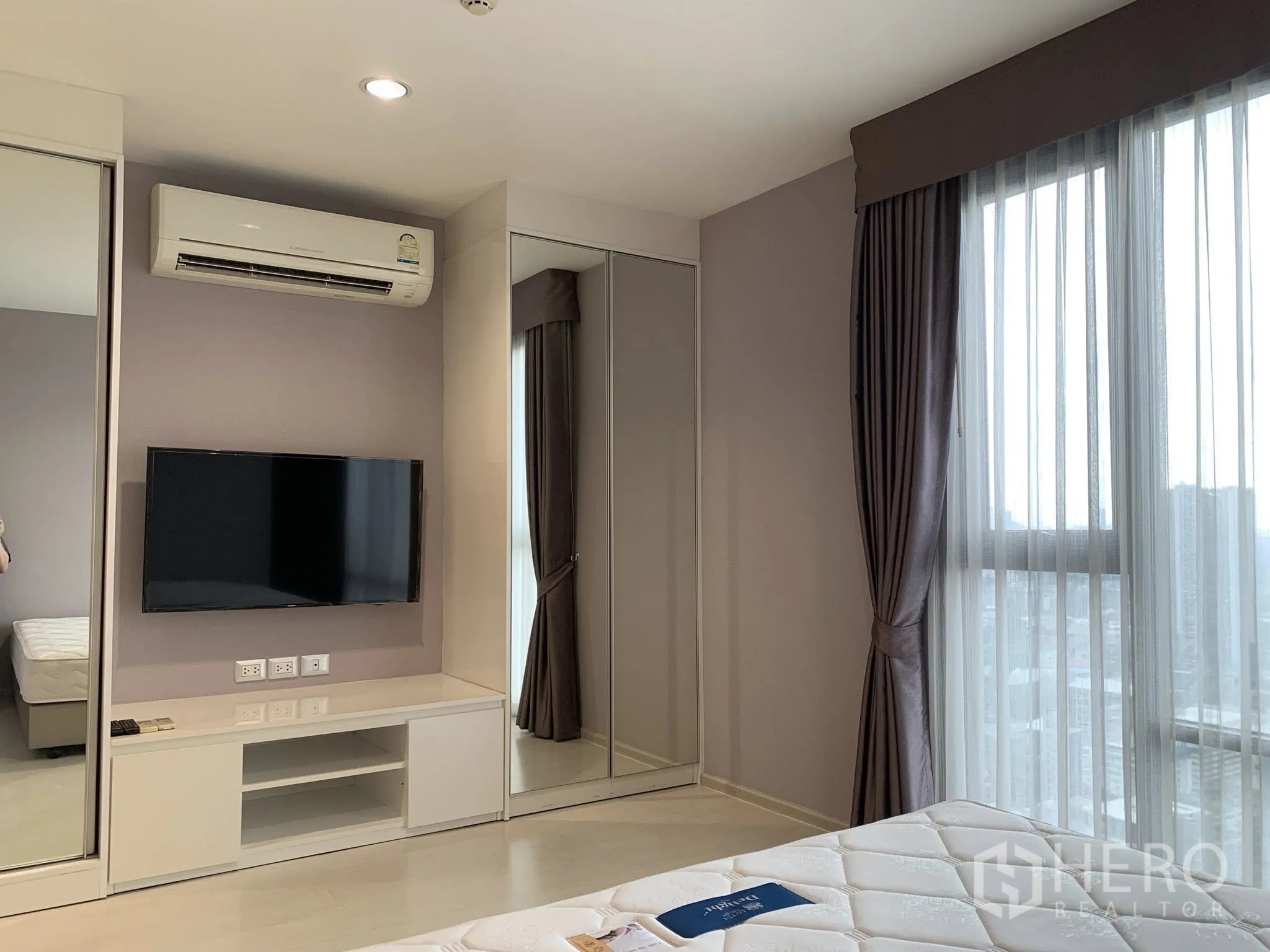 คอนโด for rent in Khlong Toei, Bangkok - ห้องนอนพร้อมตู้เสื้อผ้าบานกระจก ชั้นวางทีวี เครื่องปรับอากาศ และผ้าม่านเต็มบาน