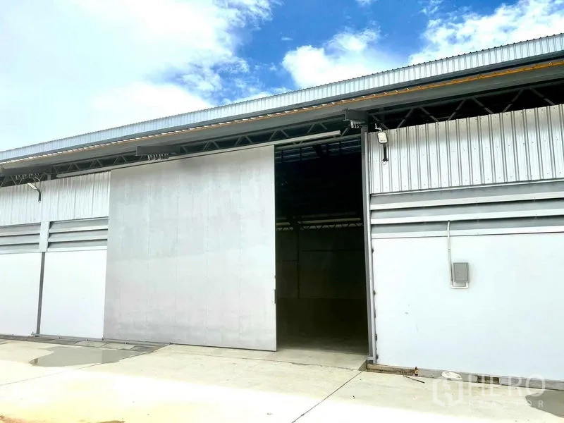 Warehouse for rent in Mueang Samut Prakan, Samut Prakan - Warehouse entrance with oversized sliding doors and a covered loading area.