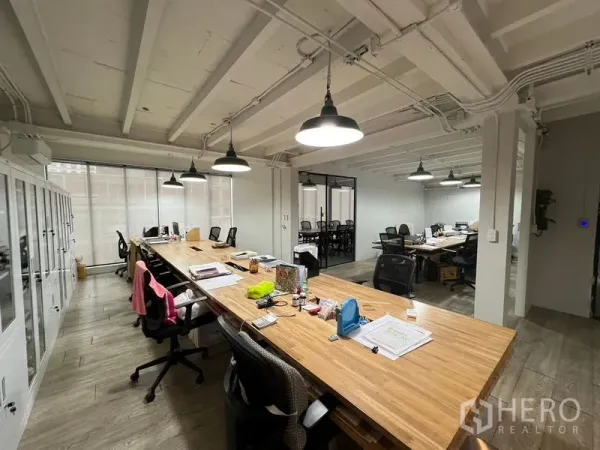 Office Space for rent in Pathum Wan, Bangkok - Spacious collaborative office featuring pendant lighting and multiple desks facing full-height windows.