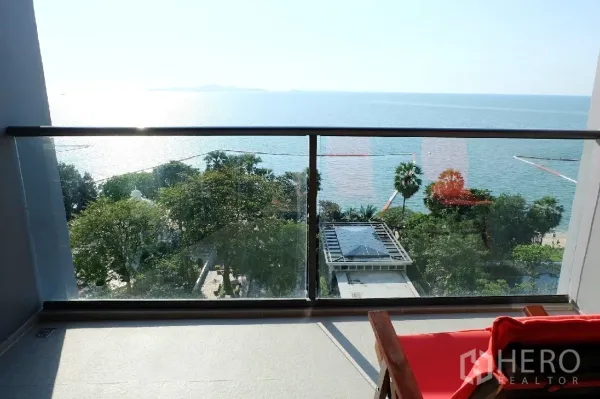 คอนโด ให้เช่าหรือขายในBang Lamung, Chon Buri - ระเบียงราวกระจก มองเห็นต้นไม้ทรอปิคอล ศาลาพูล และทะเลกว้าง