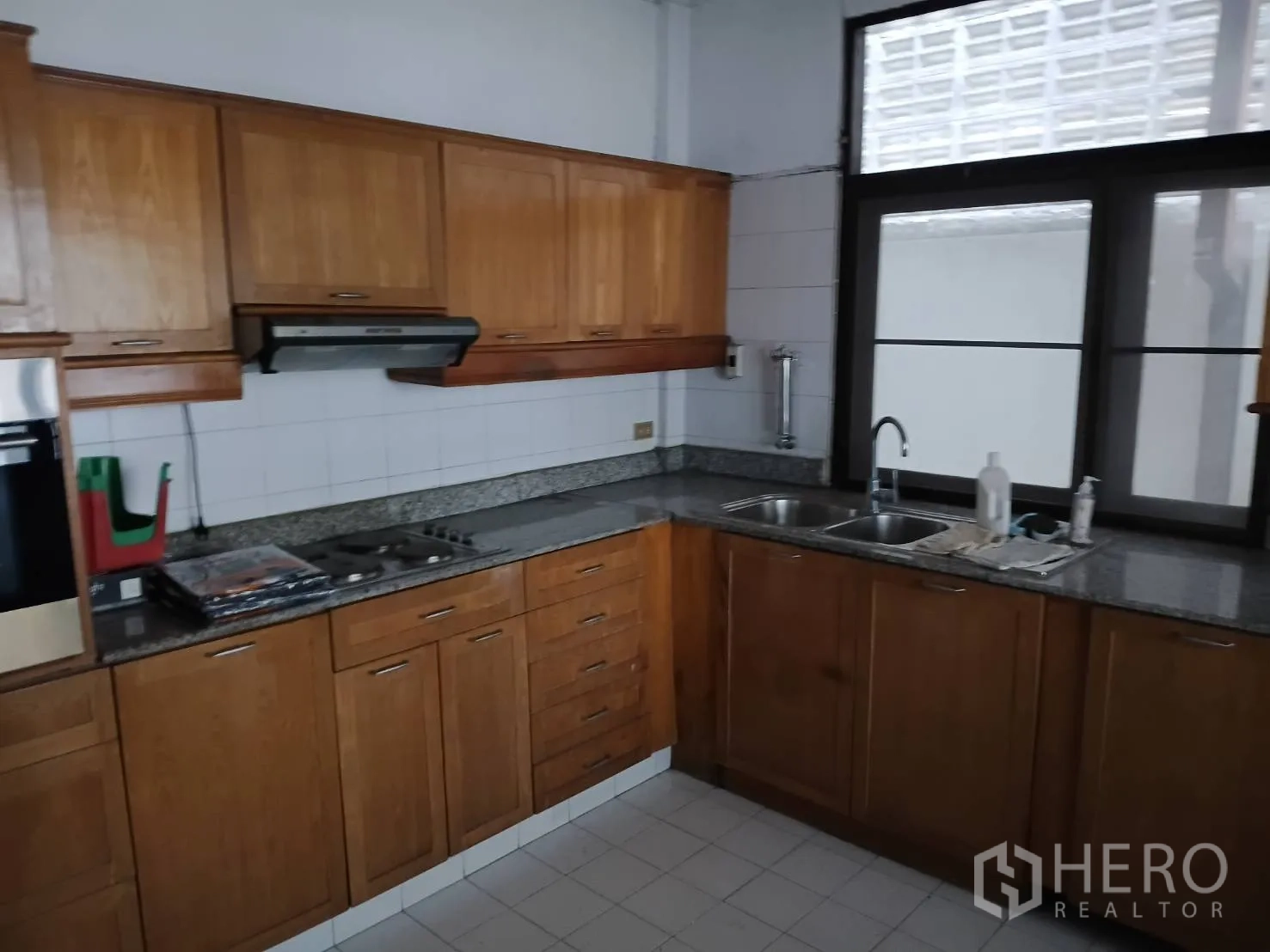 独栋房屋 for sale in Watthana, Bangkok - 另一处厨房，木柜、花岗岩台面与灶台水槽。