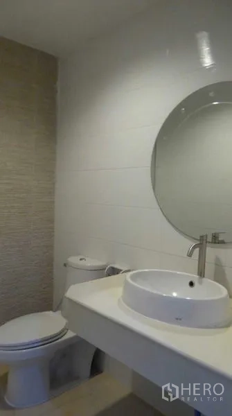Home Office for rent in Bueng Kum, Bangkok - Contemporary bathroom with round mirror, vessel sink and toilet.