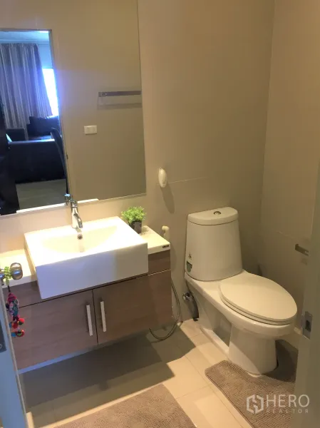 公寓 出租在Watthana, Bangkok - 第二间浴室，白色台盆、木质柜体与干净的瓷砖地面。