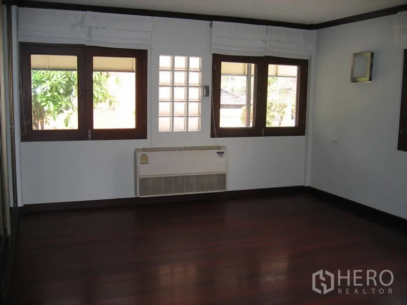独立式住宅 出租在Watthana, Bangkok - 采光卧室，多扇木框窗与壁挂空调。