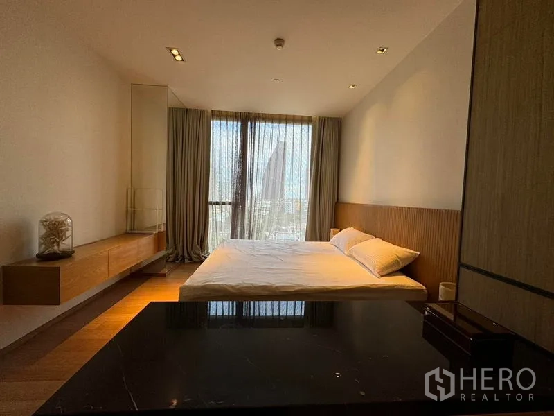 Condominium for rent in Khlong Toei, Bangkok - Spacious bedroom with king bed and large window offering skyline views.