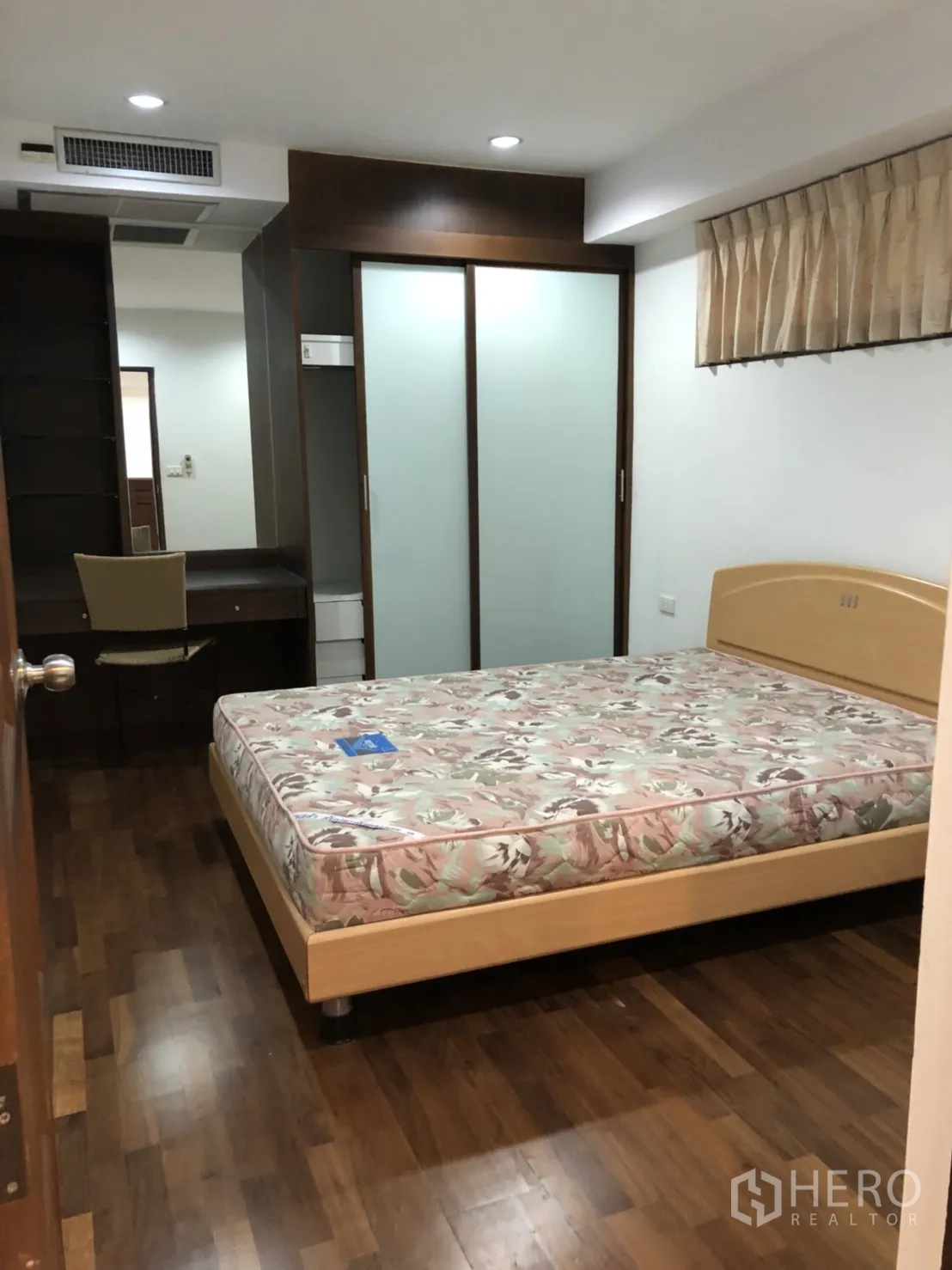 Condominium for rent in Watthana, Bangkok - Bedroom with floral mattress and frosted-glass wardrobe.