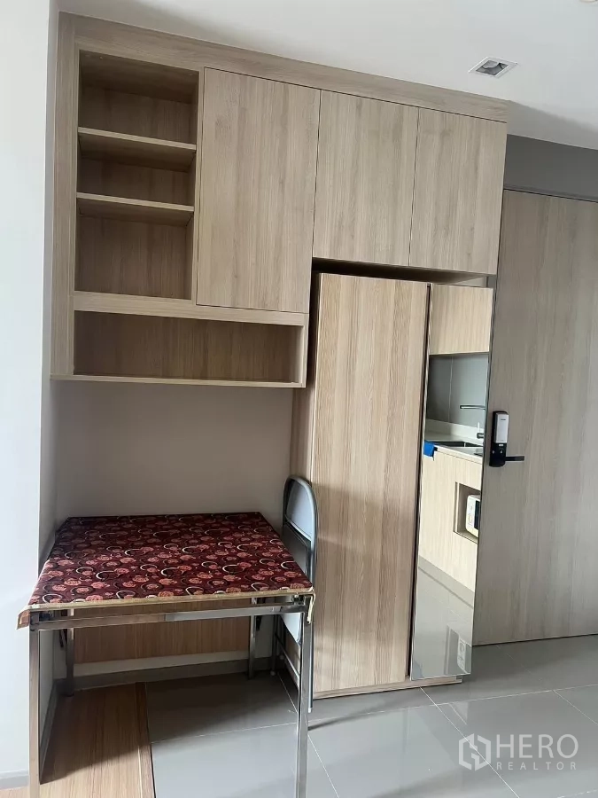 Condominium for rent or sale in Chatuchak, Bangkok - Entry storage with open shelves, foldable dining/work table and mirrored door panel.