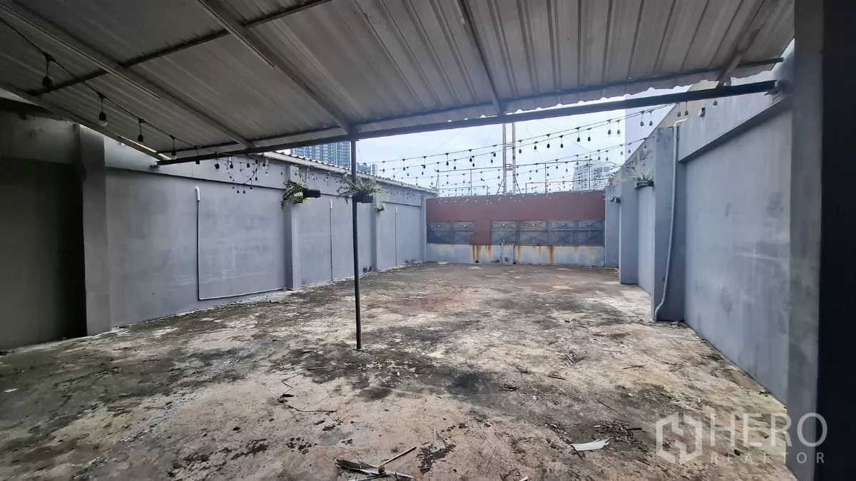 店屋 出租在Watthana, Bangkok - 屋顶露台，金属顶棚与串灯，可见远处城市景观。