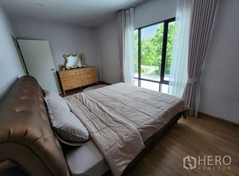 独立式住宅 出租在Prawet, Bangkok - 次卧配落地窗与绿色景观，木地板。