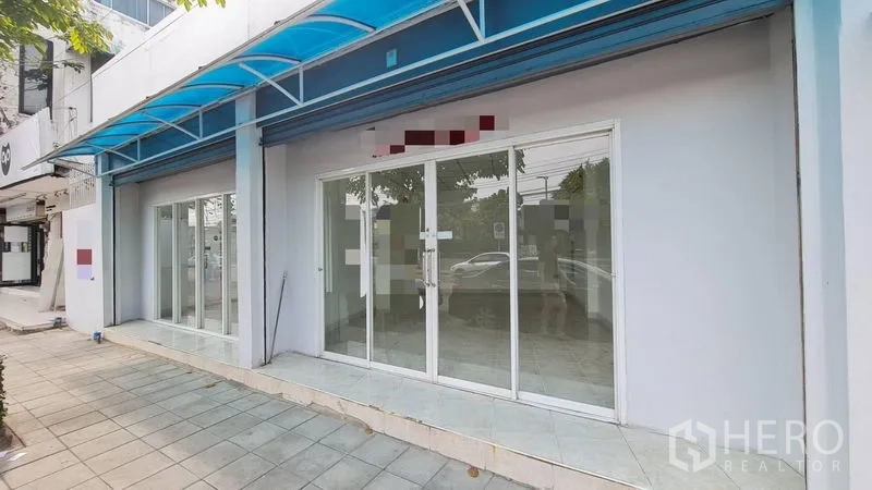 店屋 出租 - 白色外墙与落地推拉玻璃门的店面