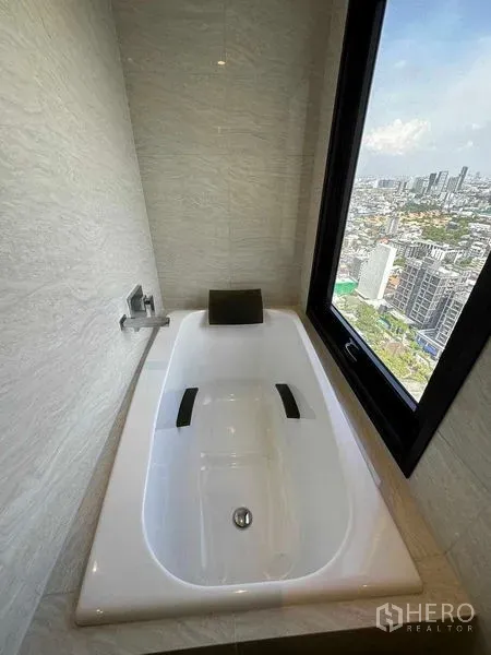 公寓 出售在Watthana, Bangkok - 嵌入式浴缸靠近落地窗，可欣赏曼谷天际线景观。